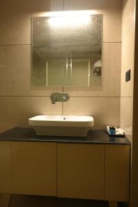 a bathroom with a sink and a mirror at Celestial International in Taliparamba +35 photos
