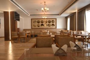 a restaurant with tables and chairs and a chandelier at Celestial International in Taliparamba