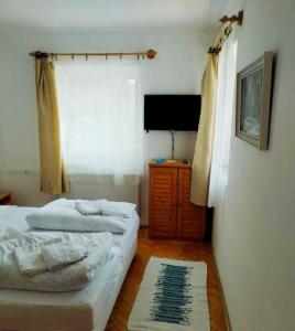 a bedroom with two beds and a television in it at Paprika vendégház in Harkány