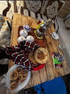 a wooden table with plates of food on it at Momo Surf Housse in Wassane