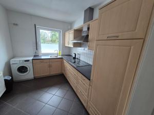 a kitchen with wooden cabinets and a washer and dryer at Brull in Lengerich