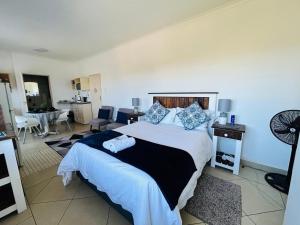 a bedroom with a large bed and a living room at Ameni Air B&B in Gqeberha