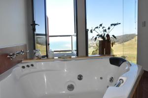 y baño con bañera y ventana grande. en Black Rock Retreat en Howth