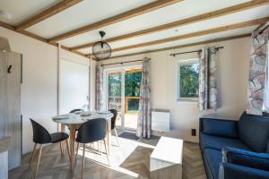 a living room with a blue couch and a table and chairs at Camping Domaine Saâne et Mer in Quiberville