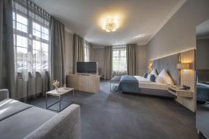 a hotel room with a bed and a television at Schlosshotel Grünwald in Grünwald +33 photos