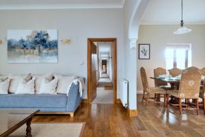 a living room with a blue couch and a dining room at Finest Retreats - The Park in Onibury