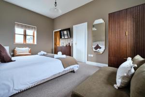 a bedroom with a large white bed and a couch at Finest Retreats - The Park in Onibury +32 photos