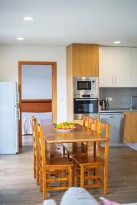 a kitchen with a wooden table and chairs with a bowl of fruit at Sousa Horizonte - Louredo in Vieira do Minho
