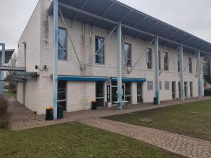 a large white building with blue accents on it at The Polo Hub in Mortara