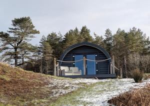 a blue dome hut with two chairs in it on a hill at Herons Rest Pod By The Sea in Morar Station