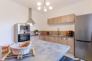 a kitchen with wooden cabinets and a stainless steel refrigerator at Clair'omer in Yèvres-le-Petit +14 photos