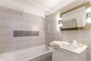a bathroom with a sink and a tub and a mirror at Clair'omer in Yèvres-le-Petit