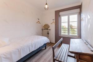 a bedroom with a bed and a window and a table at Clair'omer in Yèvres-le-Petit