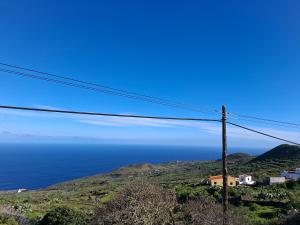 a telephone pole with the ocean in the background at Solo Tranquilidad in Mocanal