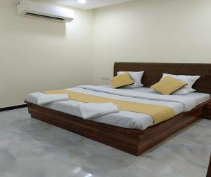 a bedroom with a large bed with yellow and white pillows at Hotel The Castle Inn in Varanasi