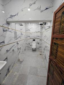 a marble bathroom with a toilet and a sink at Hotel The Castle Inn in Varanasi +14 photos
