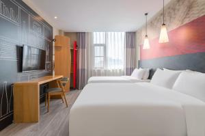 a hotel room with two beds and a desk at Ibis Chengdu Wuhouci Jinli in Chengdu