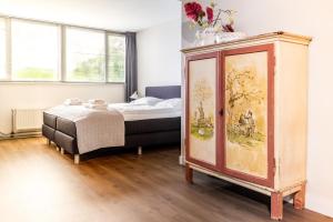 a bedroom with a bed and a dresser at Simmerwille - stilte accommodaties in nationaal park de Alde Feanen in Earnewâld