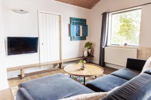 a living room with a couch and a table at Simmerwille - stilte accommodaties in nationaal park de Alde Feanen in Earnewâld