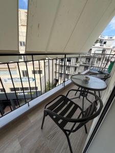 a table and a chair on a balcony at Feels Like Home 2 - Agrinio Suites in Agrinio