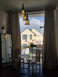 a room with a table and chairs and a large window at J's lodge in Negombo