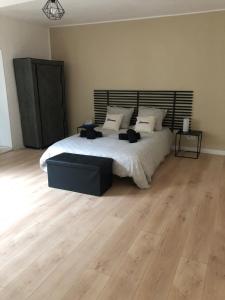 a bedroom with a large bed and a wooden floor at Chez Nath House in Sedan