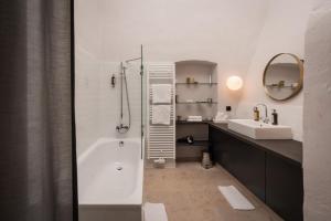 a bathroom with a white tub and a sink at Boutique Hotel Zum Oberjäger, Schloss Lackenbach in Lackenbach
