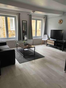 a living room with a couch and a tv at Chez Nath House in Sedan