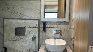 a bathroom with a white sink and a mirror at Hotel Vivaan - Walk to Banke Bihari Temple in Vrindāvan +17 photos