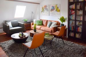 a living room with a couch and a table and chairs at Bed and Breakfast 'Op de Kleijne Hei' in Well