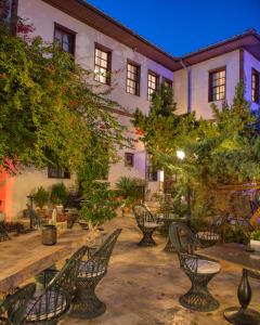a courtyard with chairs and trees and a building at Tuvana Hotel in Antalya