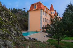 a large building with a swimming pool in front of it at Pousada da Serra da Estrela in Covilhã