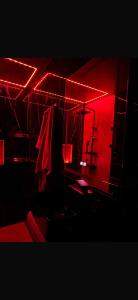 a dark room with red lights and a chair at La Garson in Borsa +3 photos