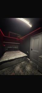 a dark room with a bed and a door at La Garson in Borsa