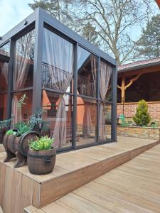 a glass conservatory on the deck of a house at Holiday&wellness house Grofica in Daruvar