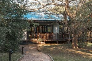 a house with a large deck in the yard at Umthiba Bush Lodge in KwaNibela