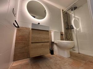 a bathroom with a toilet and a mirror at Jaén Interior LOFT in Andújar