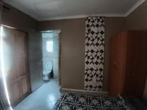 a bedroom with a bed and a door and a toilet at 12 Bologna B&B in Evander