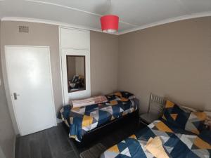 a bedroom with two beds and a mirror and a door at 12 Bologna B&B in Evander
