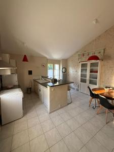 a kitchen with a counter and a table in it at Gîte à la campagne in Meursac