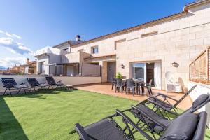 a patio with chairs and tables on a lawn at Jouvacations Ripolles Figueres-Vilafant in Vilafant