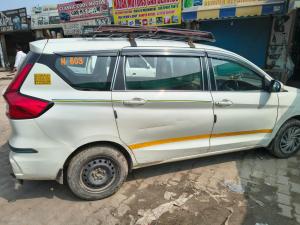 a white car with a surfboard on top of it at Bela bhavan in Kānpur
