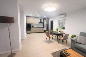 a living room with a table and chairs and a kitchen at Ran Garden Aparts in Popeşti-Leordeni