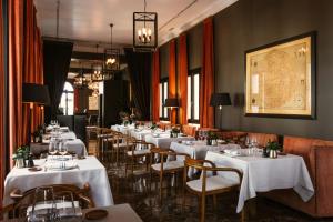 a row of tables in a restaurant with white tables and chairs at The Principal Madrid, Small Luxury Hotels in Madrid