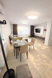 a living room with a table and chairs and a couch at Ran Garden Aparts in Popeşti-Leordeni