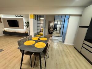 a dining room with a table and chairs and a television at Ran Garden Aparts in Popeşti-Leordeni +10 photos