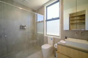 a bathroom with a toilet and a sink and a shower at Waverley Gardens Modern 3BR Home - Pet Friendly & Parking in Mulgrave