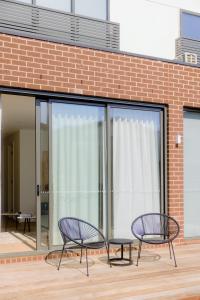 two chairs and a table in front of a building at Waverley Gardens Modern 3BR Home - Pet Friendly & Parking in Mulgrave +22 photos