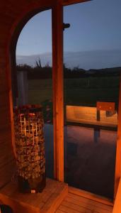 a glass door of a boat with a basket of wood at STUNNING FARM COTTAGES at South Downs Rural Retreats in Worthing