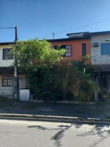a house with a fence and a tree at Casa Completa na Praia in Saquarema
